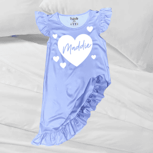 Soft lavender ruffled baby dress with personalized "Maddie" heart design, perfect for special occasions or everyday comfort.