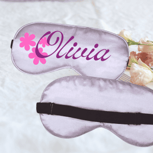 Sleep mask with personalized name "Mia" and pink flower design, perfect for relaxing and restful sleep.